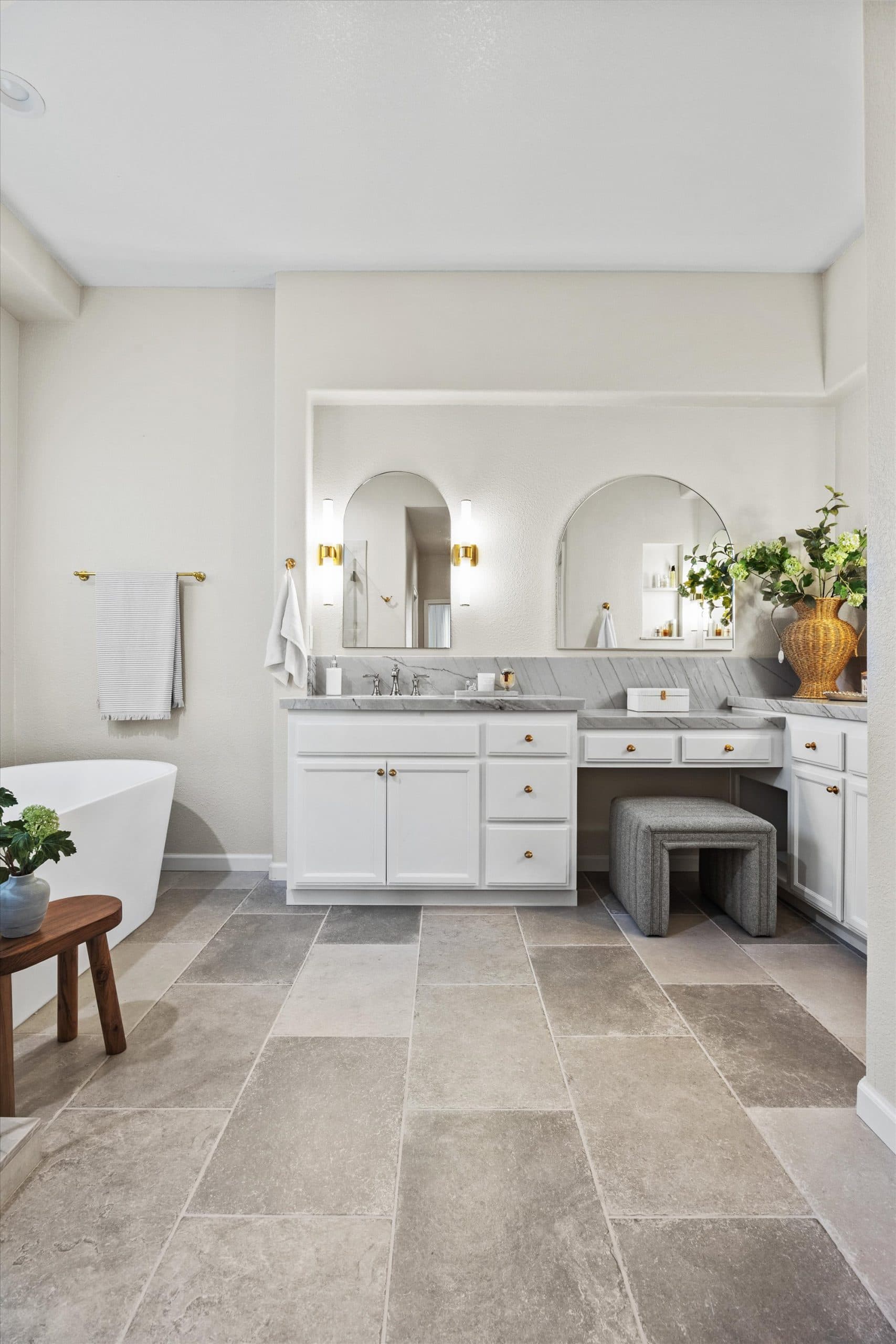 Full room view of remodeled master bathroom with dual vanity, freestanding tub, and tile flooring